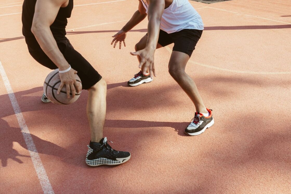 Två basketspelare i närkamp på en utomhusplan